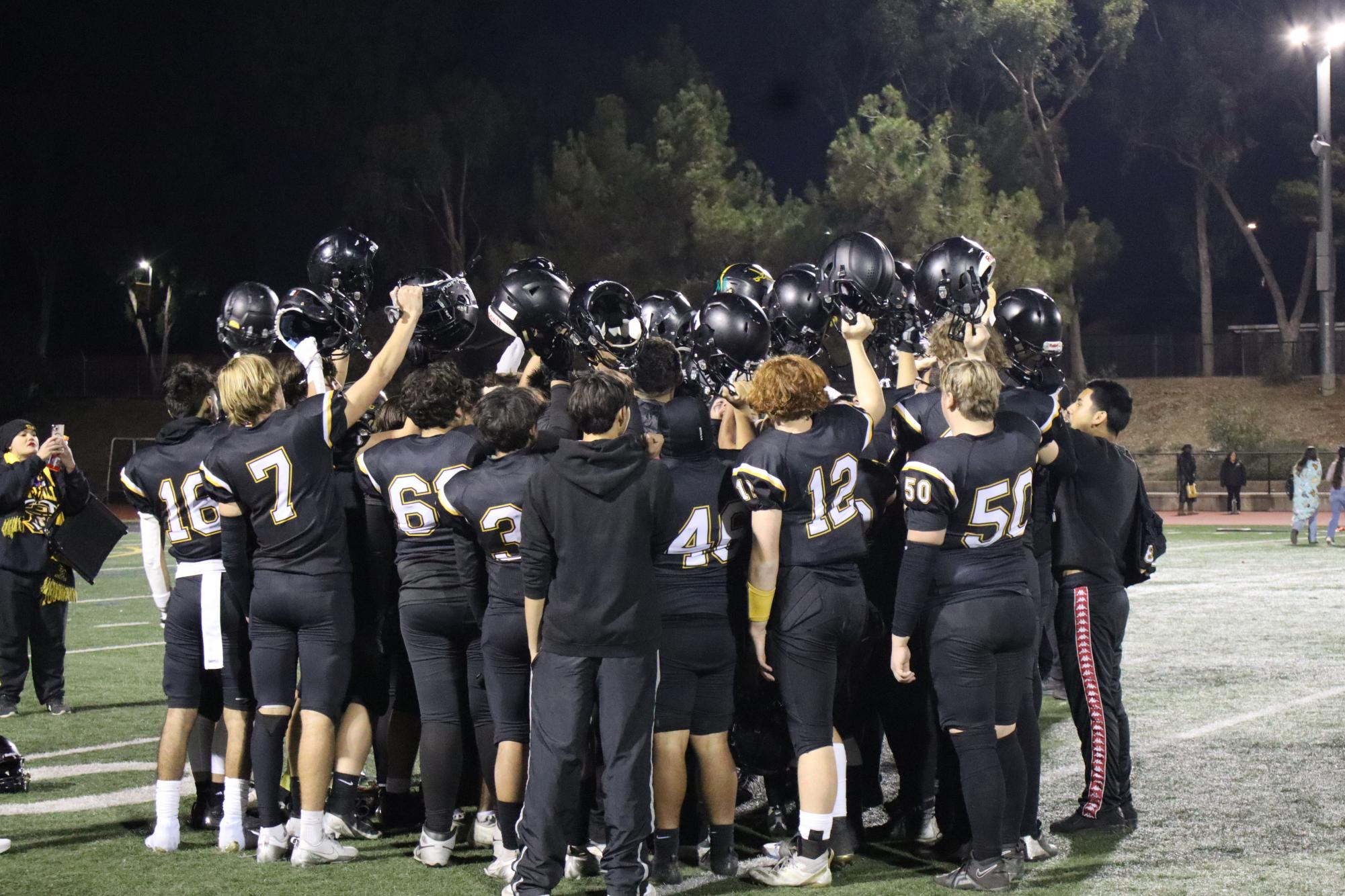 Varsity football team celebrates after final game.