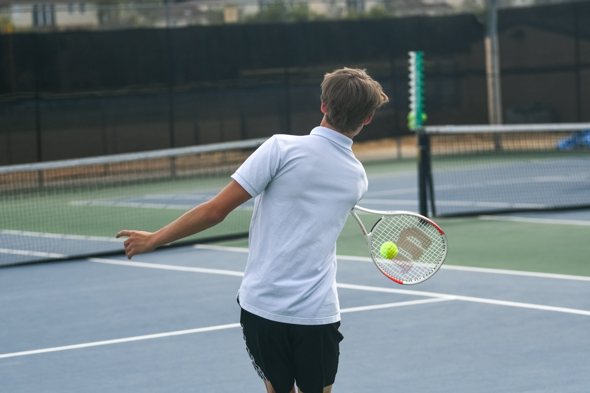 Boys tennis player Gavin Hunt active on the court. 
