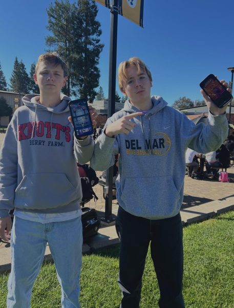 Brandon Avery (11) and Nick Rienhart (11) holding up clash royal on their phones.