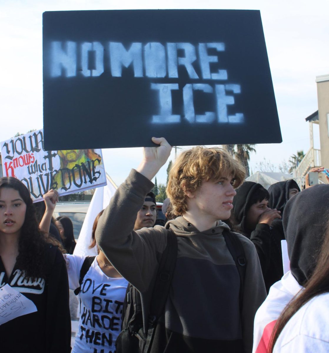 Del Mar student, senior Eamonn Baker, holds a "No More Ice" sign at an anti-ice protest on Tuesday, January 20th. 