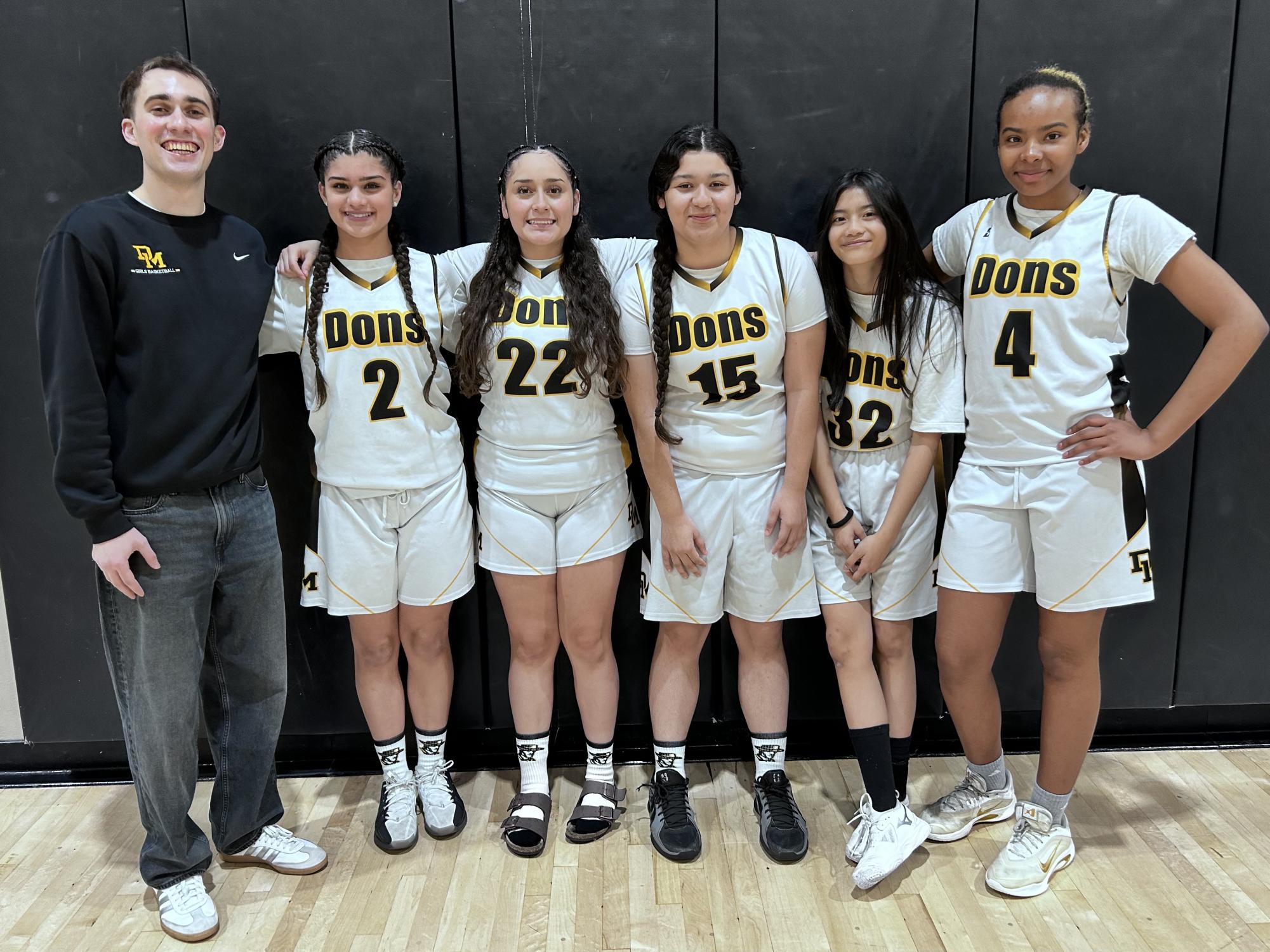 The Dons team poses together on the court following the game.