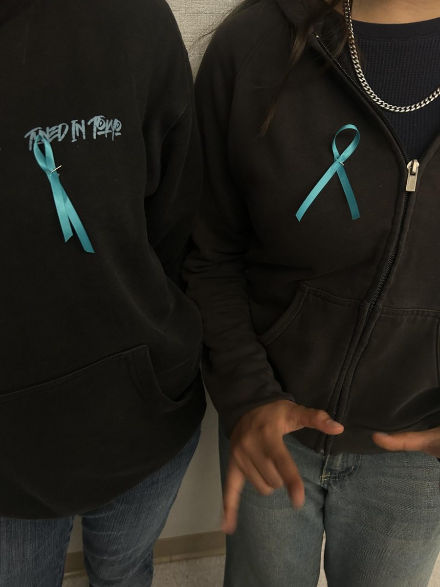 Students raise sexual assault awareness with teal ribbons. 